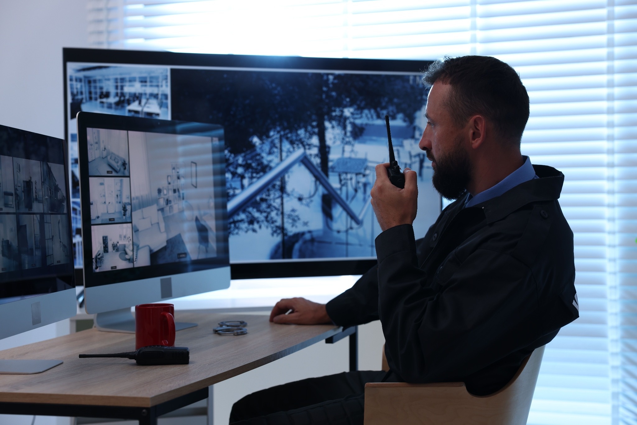 security guard sitting at desk monitoring cameras